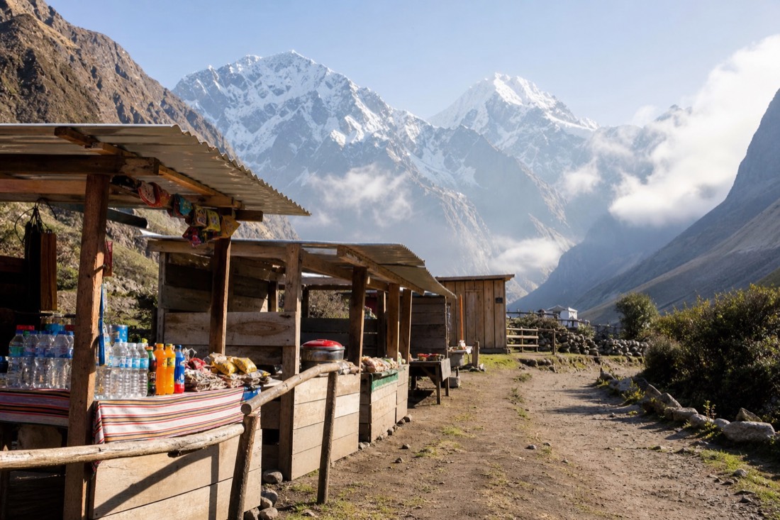 A row of simple wooden refreshment stalls selling bottled water and snacks at the Soraypampa trailhead, Andean valley and the Salkantay massif in the distance, morning, no recognizable faces
